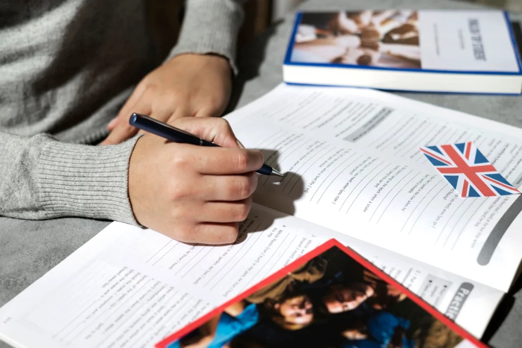 Persoana care scrie intr-o carte si invata pentru examenul Cambridge