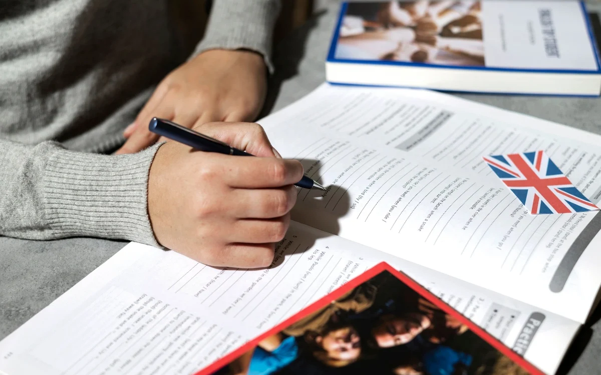 Persoana care scrie intr-o carte si invata pentru examenul Cambridge
